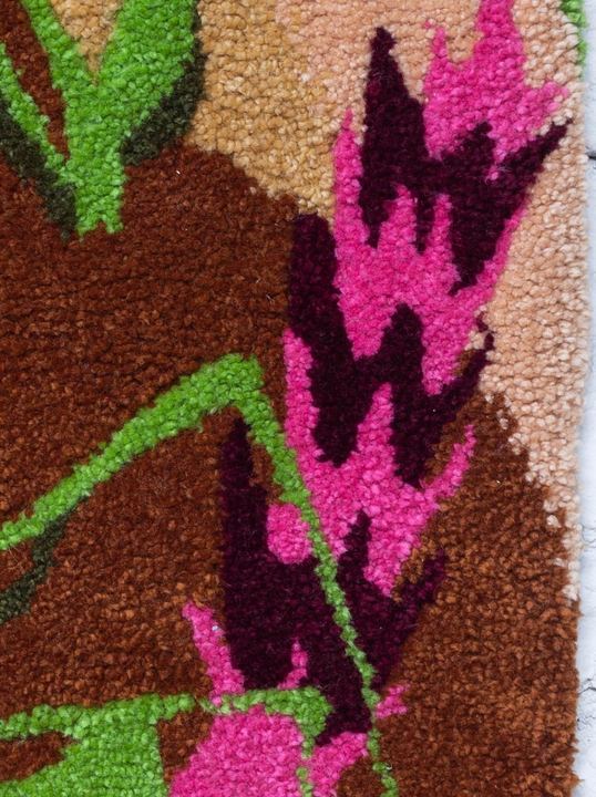 Detail růžového květu a zelených listů z vlny