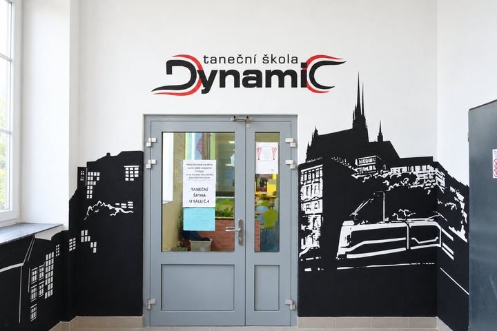 Logo Taneční školy Dynamic nad černou siluetou Brna u vstupu