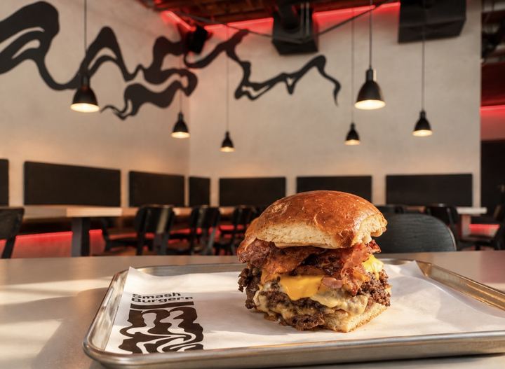 Burger na stole pod malbou v restauraci SMASH Burger