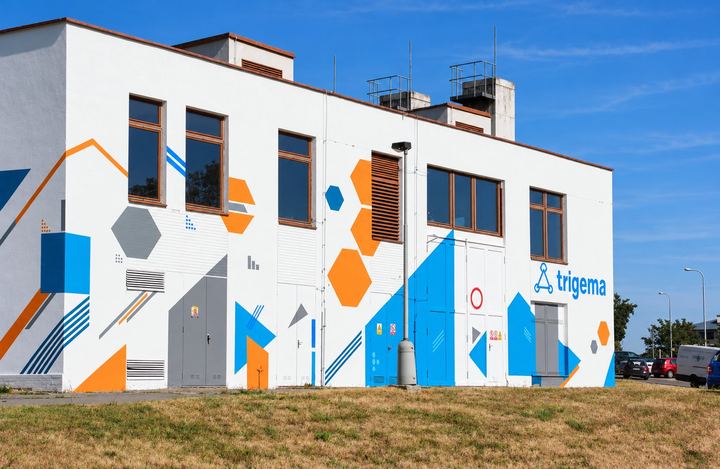 Trafostanice v Nových Butovicích s modrými a oranžovými tvary a logem Trigema