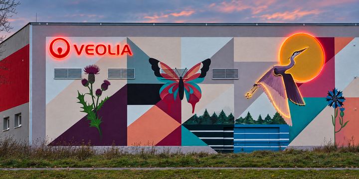 Malba s neonovým logem Veolia a sluncem