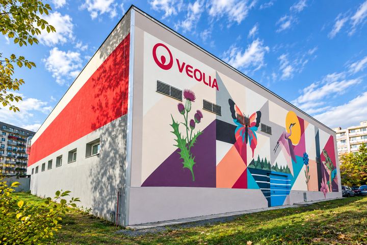 Nároží budovy s logem Veolia, bodlákem a motýlem